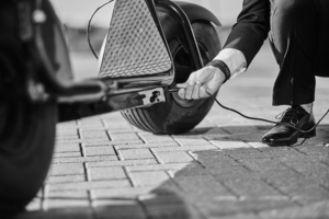 Man bending down to put a car on charge