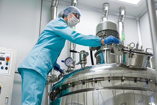 Scientists stood over a reactor