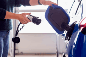 EV charger being plugged into a blue car