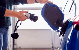 EV charger being plugged into a blue car